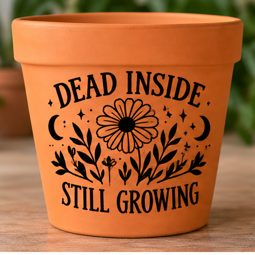 Orange plant pot with black flowers, crescent moons and Dead Inside Still Growing lettering
