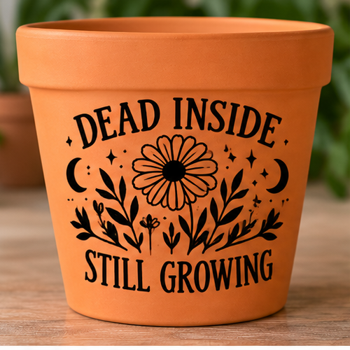 Orange plant pot with black flowers, crescent moons and Dead Inside Still Growing lettering